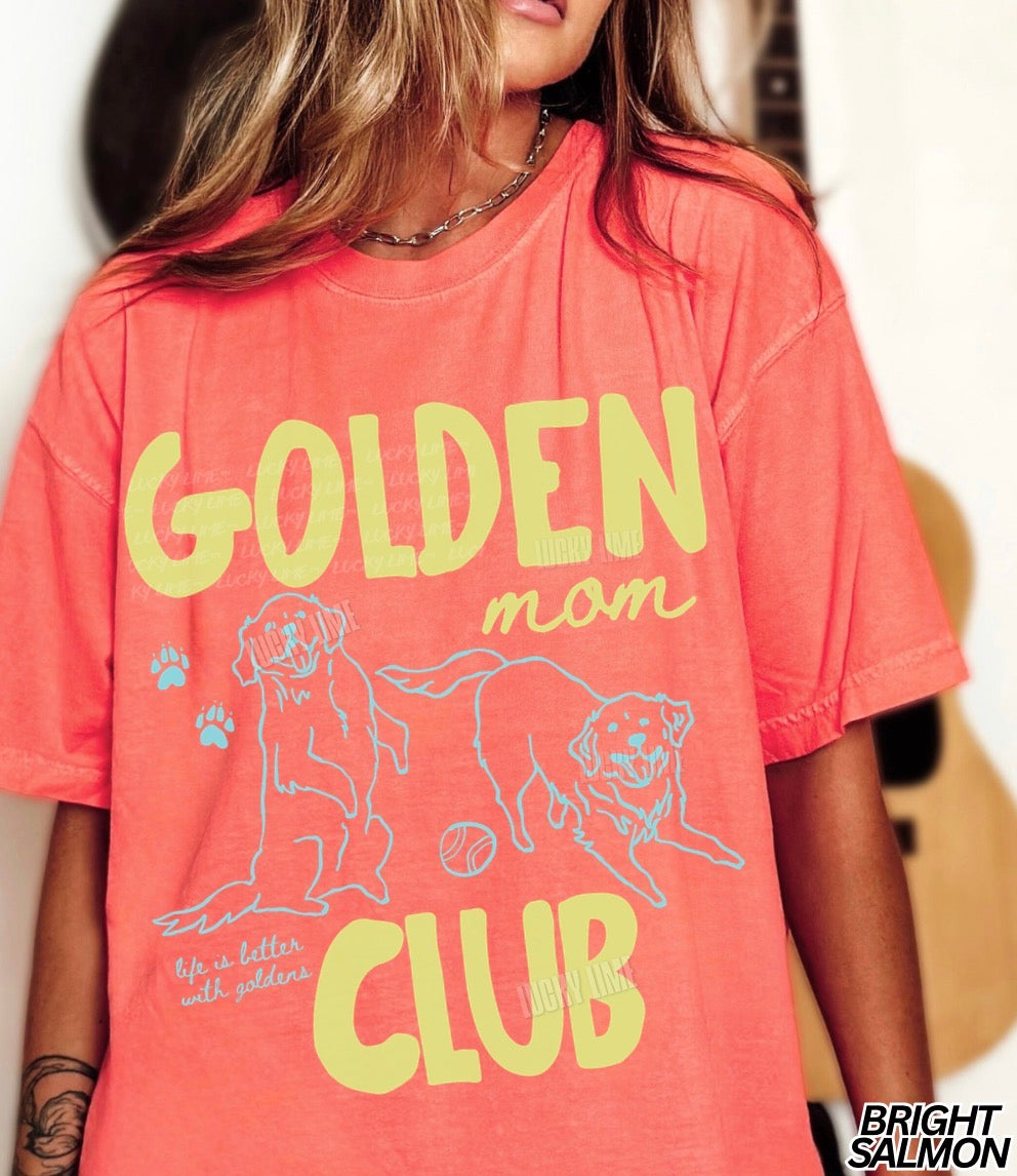 Person wearing a coral t-shirt with 'Golden Mom Club' text and graphics.