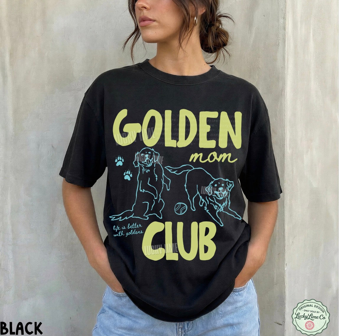 Person wearing a black t-shirt with 'Golden Mom Club' text and graphics against a light gray background.