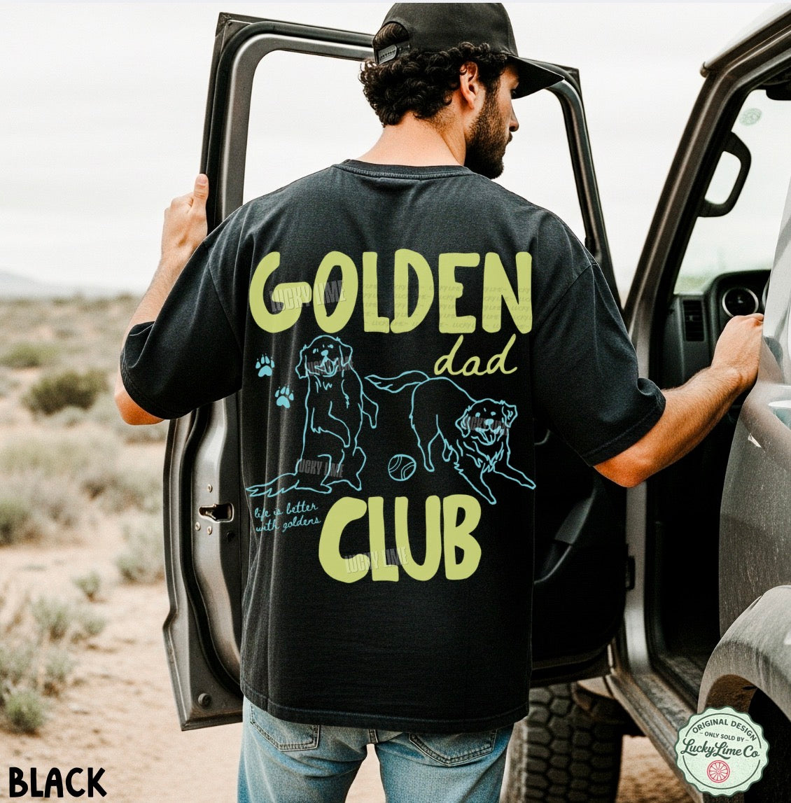 Man wearing a black t-shirt with 'Golden Dad Club' text and graphics, standing next to a car in a desert setting.