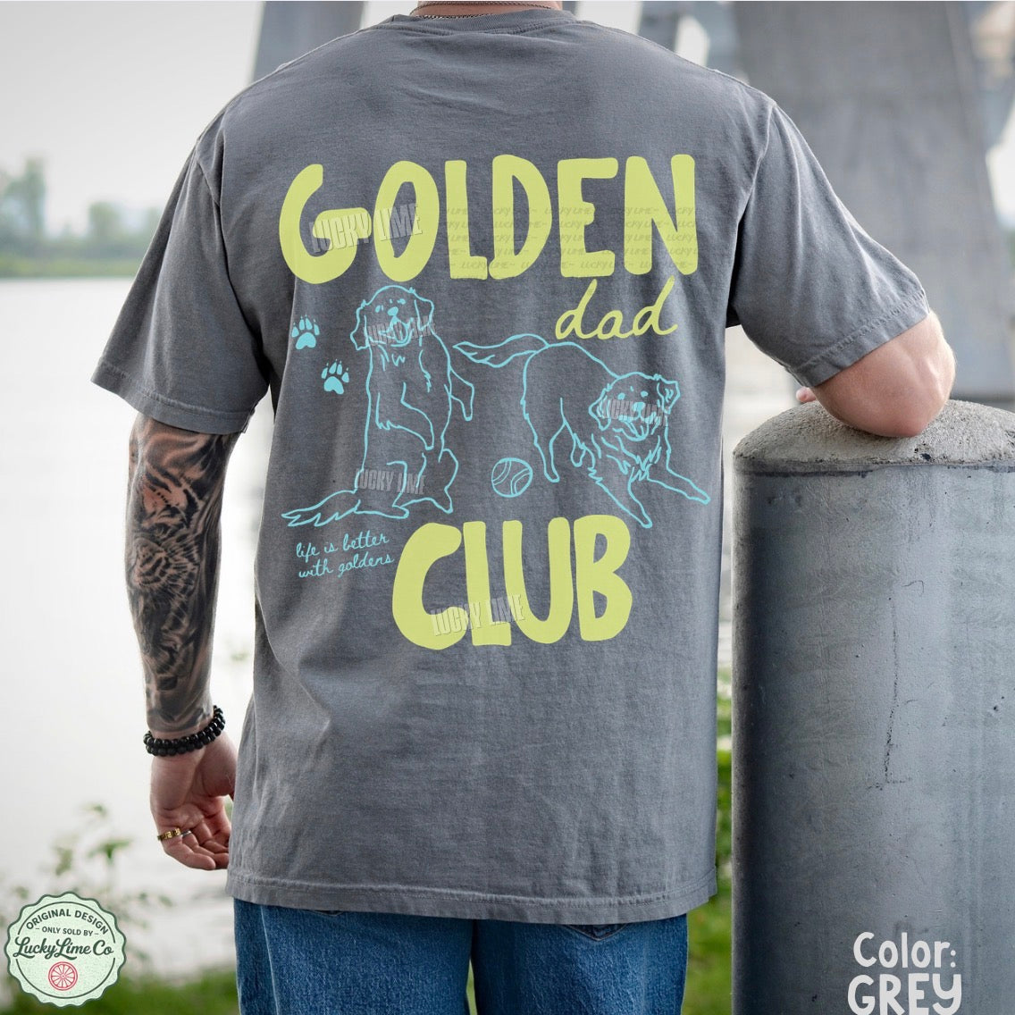 Person wearing a gray t-shirt with 'Golden Dad Club' design outdoors.