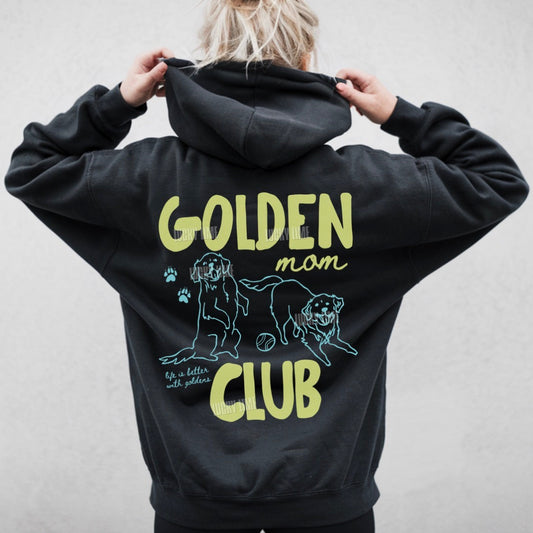 Black hoodie with 'Golden Mom Club' text and dog illustration on the back, worn by a person.