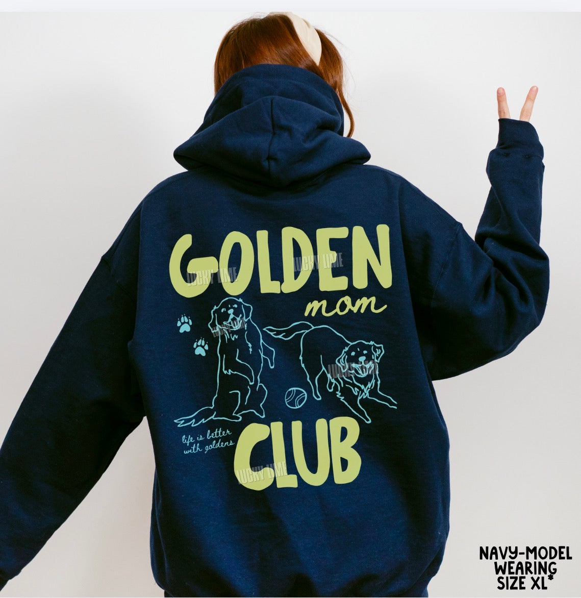 Navy hoodie with 'Golden Mom Club' text and dog illustrations on the back, worn by a person.