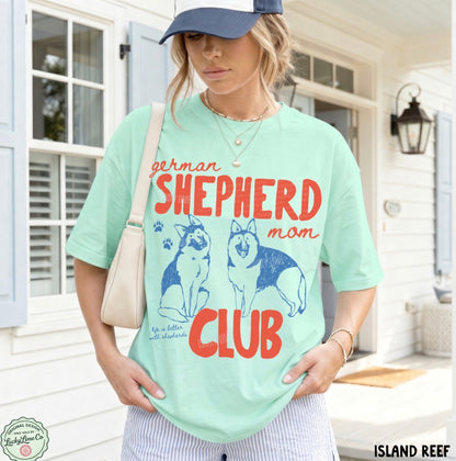 Woman wearing a light green t-shirt with 'German Shepherd mom club' design outdoors.