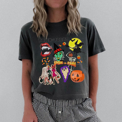 Person wearing a dark gray t-shirt with Halloween-themed graphics and checkered shorts on a plain background.