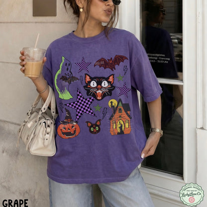 Person wearing a purple Halloween-themed t-shirt with various graphics, holding a drink.