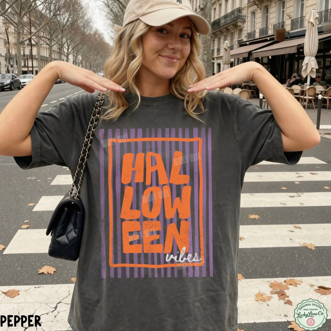 Woman wearing a 'HALLOWEEN vibes' t-shirt on a city street.