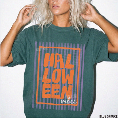 Person wearing a green t-shirt with 'HALLOWEEN vibes' text design.