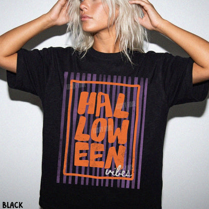 Person wearing a black t-shirt with 'HALLOWEEN vibes' text in orange and purple on a white background