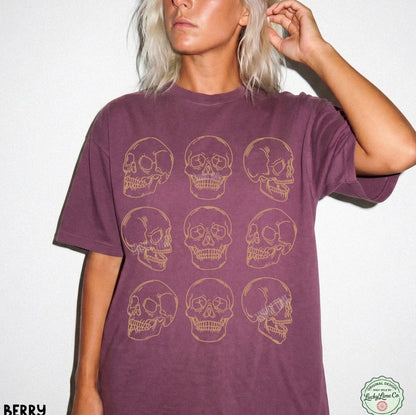 Person wearing a purple t-shirt with gold skull designs on a white background