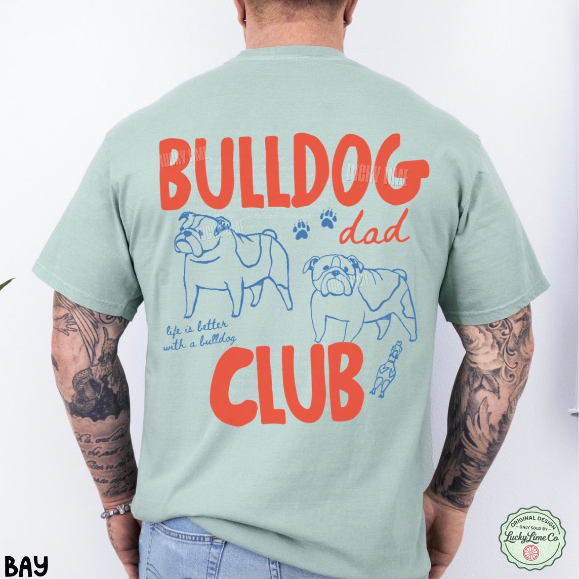 Person wearing a light green t-shirt with 'Bulldog Dad Club' text and graphics on the back.