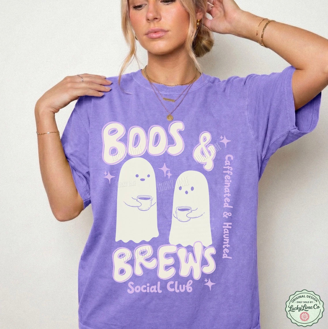 Person wearing a purple t-shirt with ghost graphics and text on a plain background