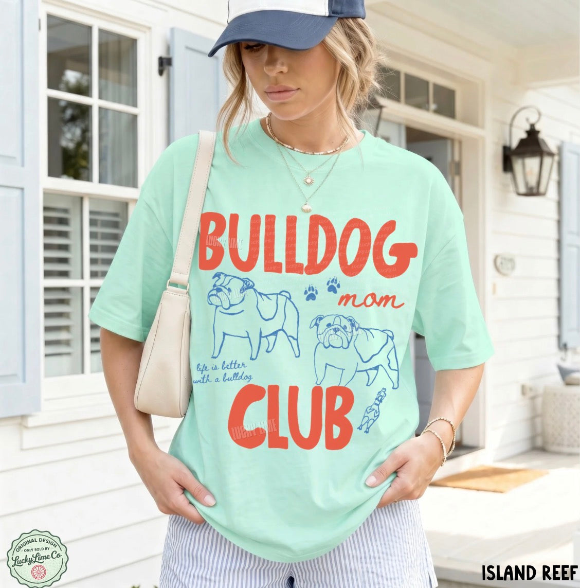Woman wearing a light green t-shirt with 'Bulldog Mom Club' text and graphics, standing outdoors.