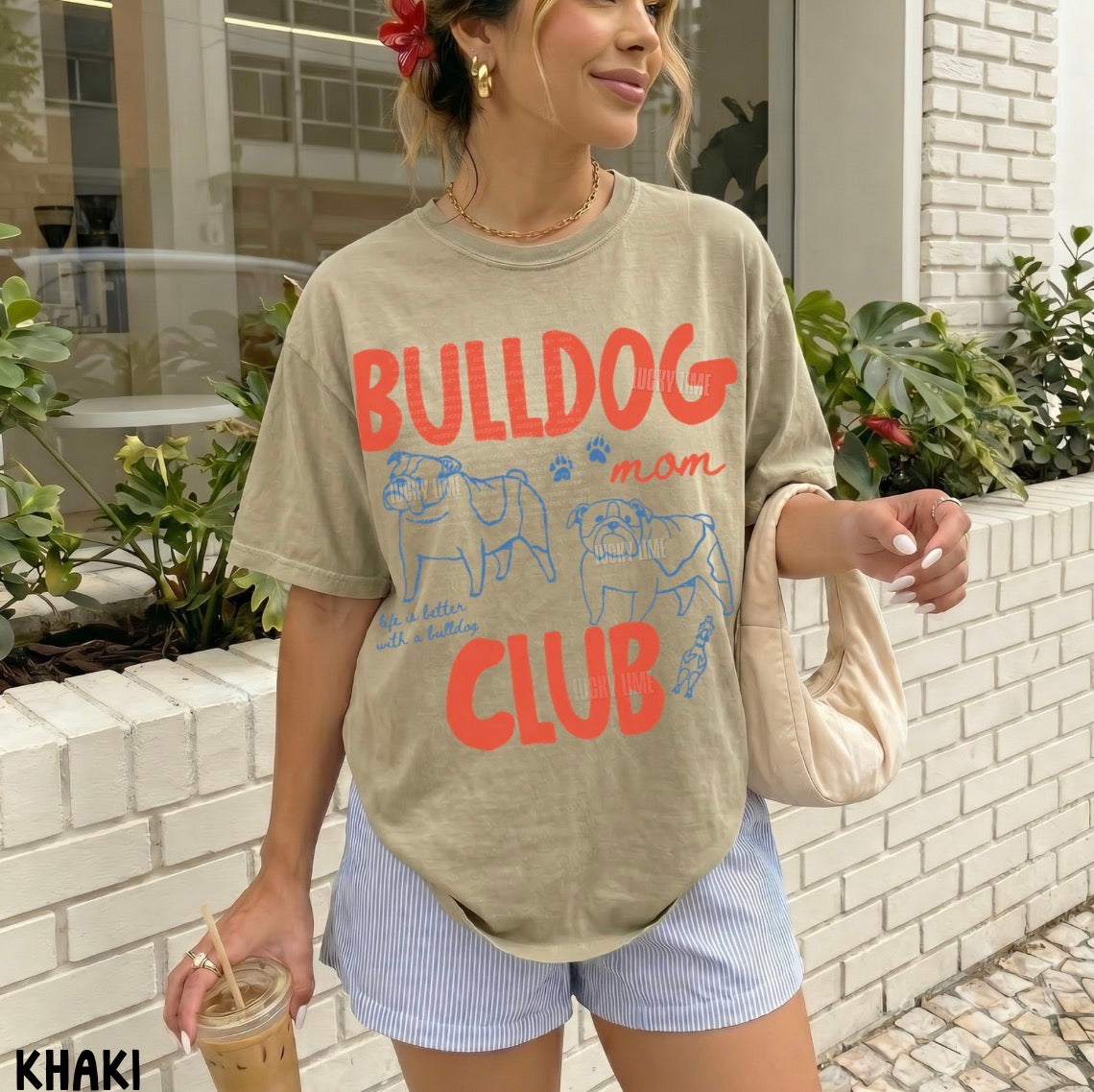 Woman wearing a 'Bulldog Mom Club' t-shirt outdoors.