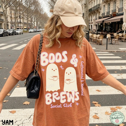 Person wearing a 'Boos & Brews Social Club' t-shirt on a city street.