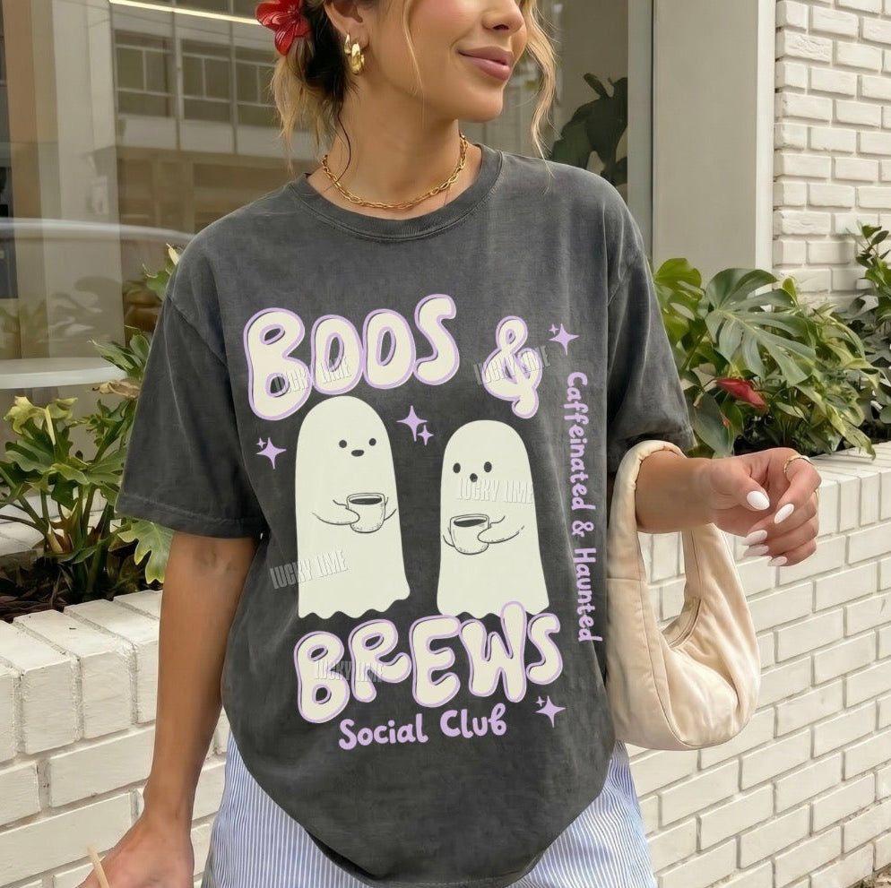 Person wearing a t-shirt with ghost graphics and text, holding a coffee cup outdoors.