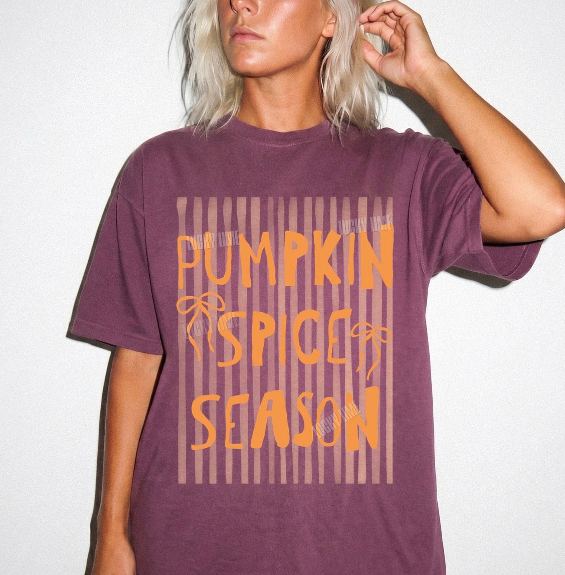 Person wearing a purple t-shirt with 'Pumpkin Spice Season' text on a white background