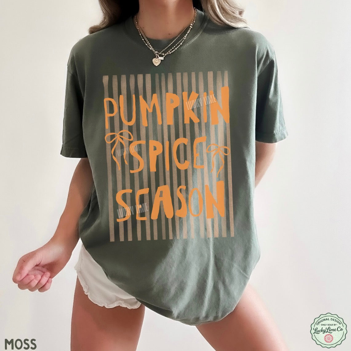 Person wearing a green t-shirt with 'Pumpkin Spice Season' text on a plain background