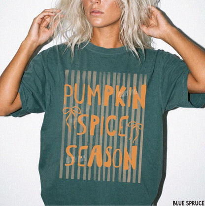 Person wearing a green t-shirt with 'Pumpkin Spice Season' text on a white background
