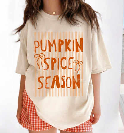 Person wearing a 'Pumpkin Spice Season' t-shirt with red checkered shorts.