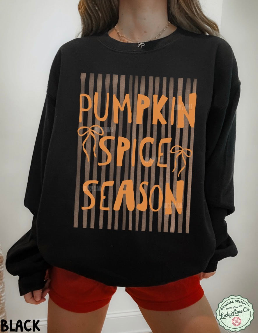 Black sweatshirt with 'Pumpkin Spice Season' text worn by a person, on a plain background.