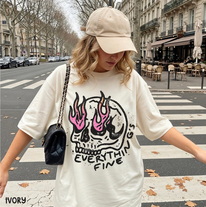 Person wearing a white t-shirt with a skull design and text, standing on a city street.
