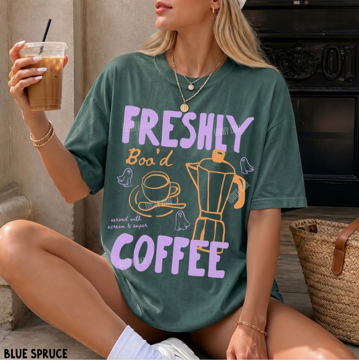 Person wearing a green t-shirt with 'Freshly Bod' and 'Coffee' text, holding a drink.