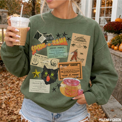 A woman wearing an olive green crewneck sweatshirt with a collage of vintage Halloween-themed stickers and graphics, holding an iced coffee in a fall outdoor setting.