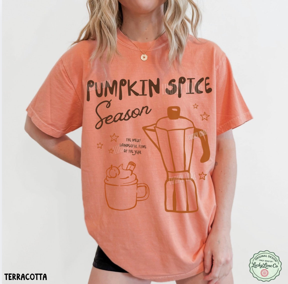 A woman wearing a terracotta-colored graphic t-shirt with 'Pumpkin Spice Season' text and illustrations of a mug and moka pot. The brand 'The Affection Co' is visible in a watermark logo in the bottom right corner.