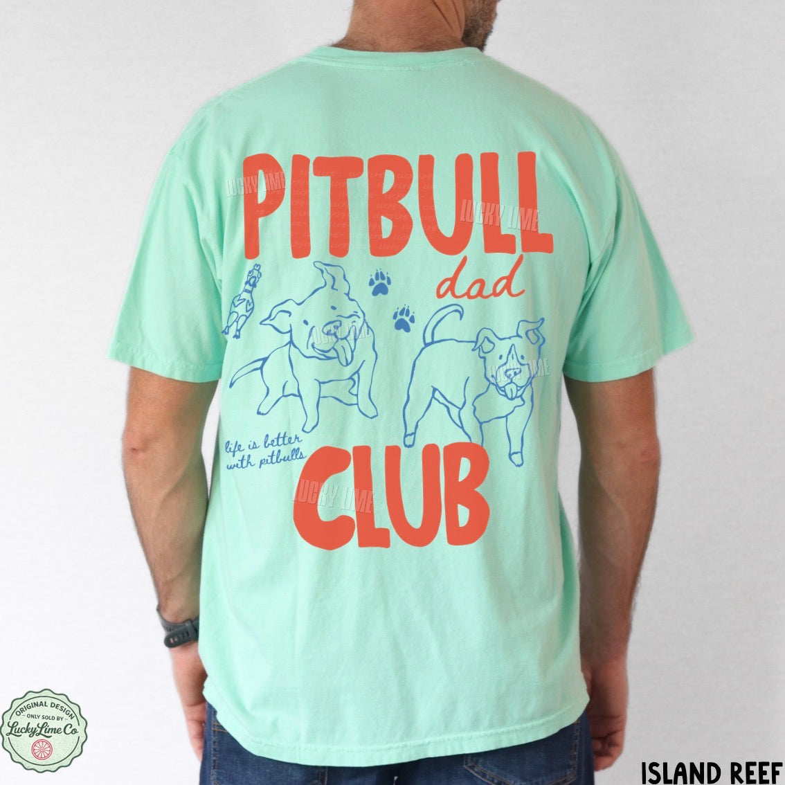 A man wearing a mint green t-shirt from the back, featuring a graphic print with the words 'PITBULL dad CLUB' in red and blue illustrations of pitbull dogs. The brand 'Island Reef' is visible on the bottom right corner and as a watermark/logo on the shirt.