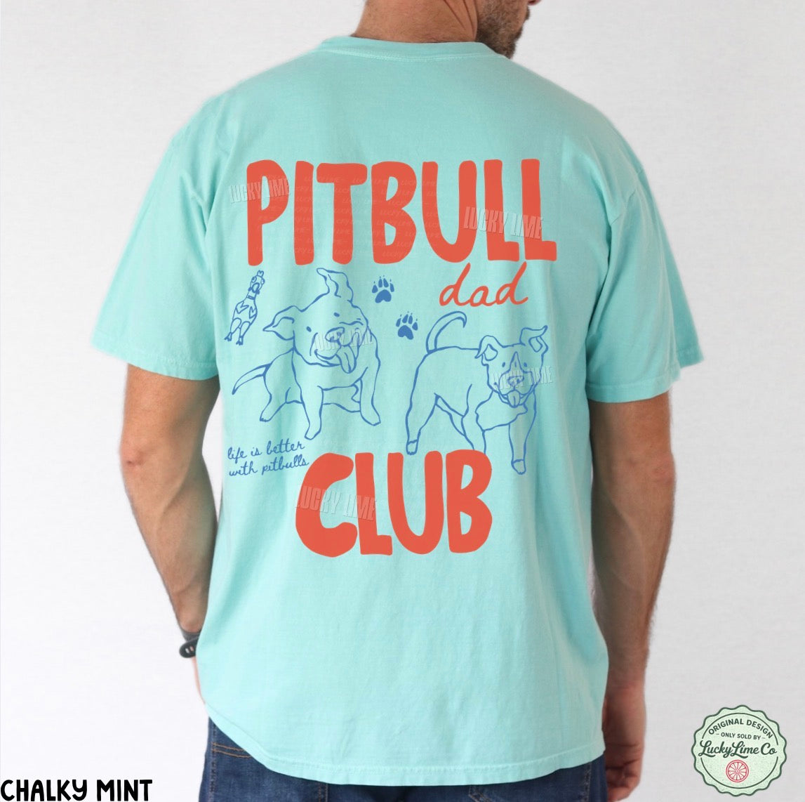 A man shown from the back wearing a light mint green t-shirt with a large graphic print on the back. The graphic features the words 'PITBULL dad CLUB' in bold orange-red lettering, accompanied by blue line drawings of two pitbull dogs and small paw prints.