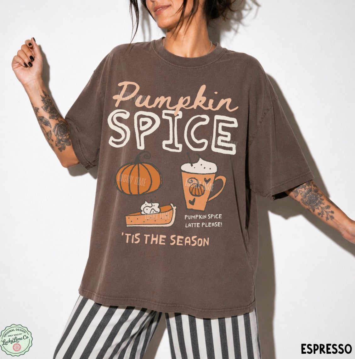 A woman wearing an oversized brown graphic t-shirt with 'Pumpkin Spice' text and autumn illustrations, paired with black and white striped pants, against a plain white background.