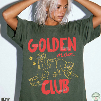 A woman wearing an oversized olive green graphic T-shirt with red and yellow text reading 'GOLDEN mom CLUB' and dog illustrations, posed against a light gray background.