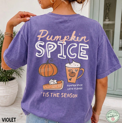 A woman wearing a violet short-sleeve graphic t-shirt, viewed from the back. The shirt features a colorful 'Pumpkin Spice' autumn-themed design with a pumpkin, a latte, and a cat.