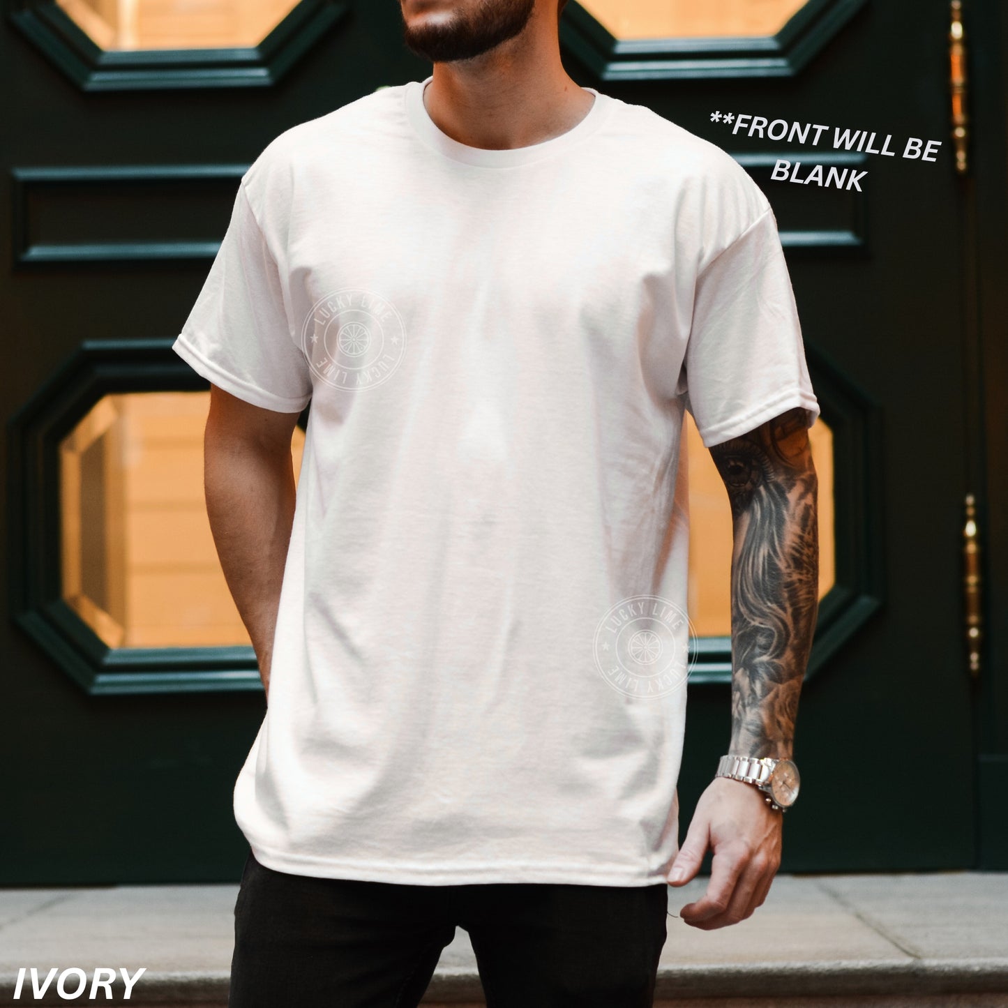 Person wearing a white t-shirt with text 'FRONT WILL BE BLANK' above, standing in front of a dark door.