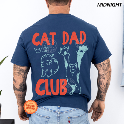 Person wearing a navy blue t-shirt with 'Cat Dad Club' design on the back, with tattoos visible.