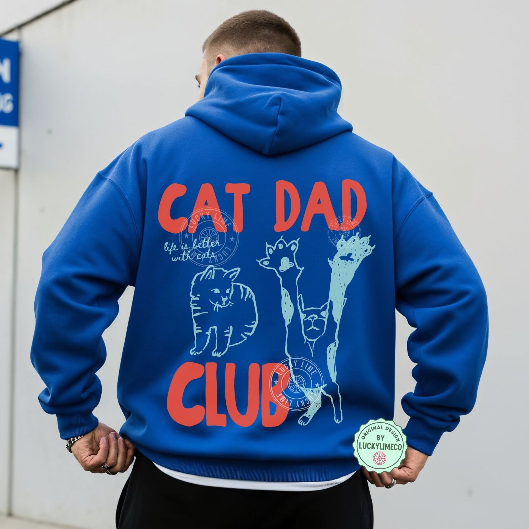 Person wearing a blue hoodie with 'Cat Dad Club' text and graphics on the back.