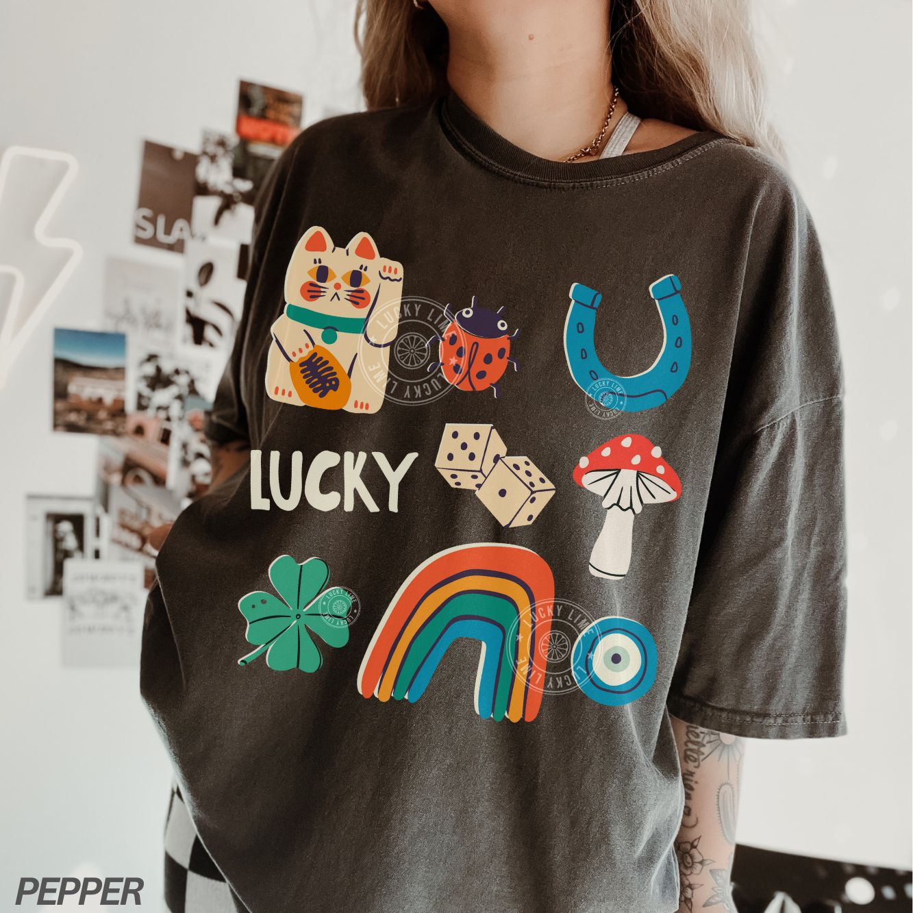 Person wearing a dark gray t-shirt with colorful lucky symbols and the word 'LUCKY'.