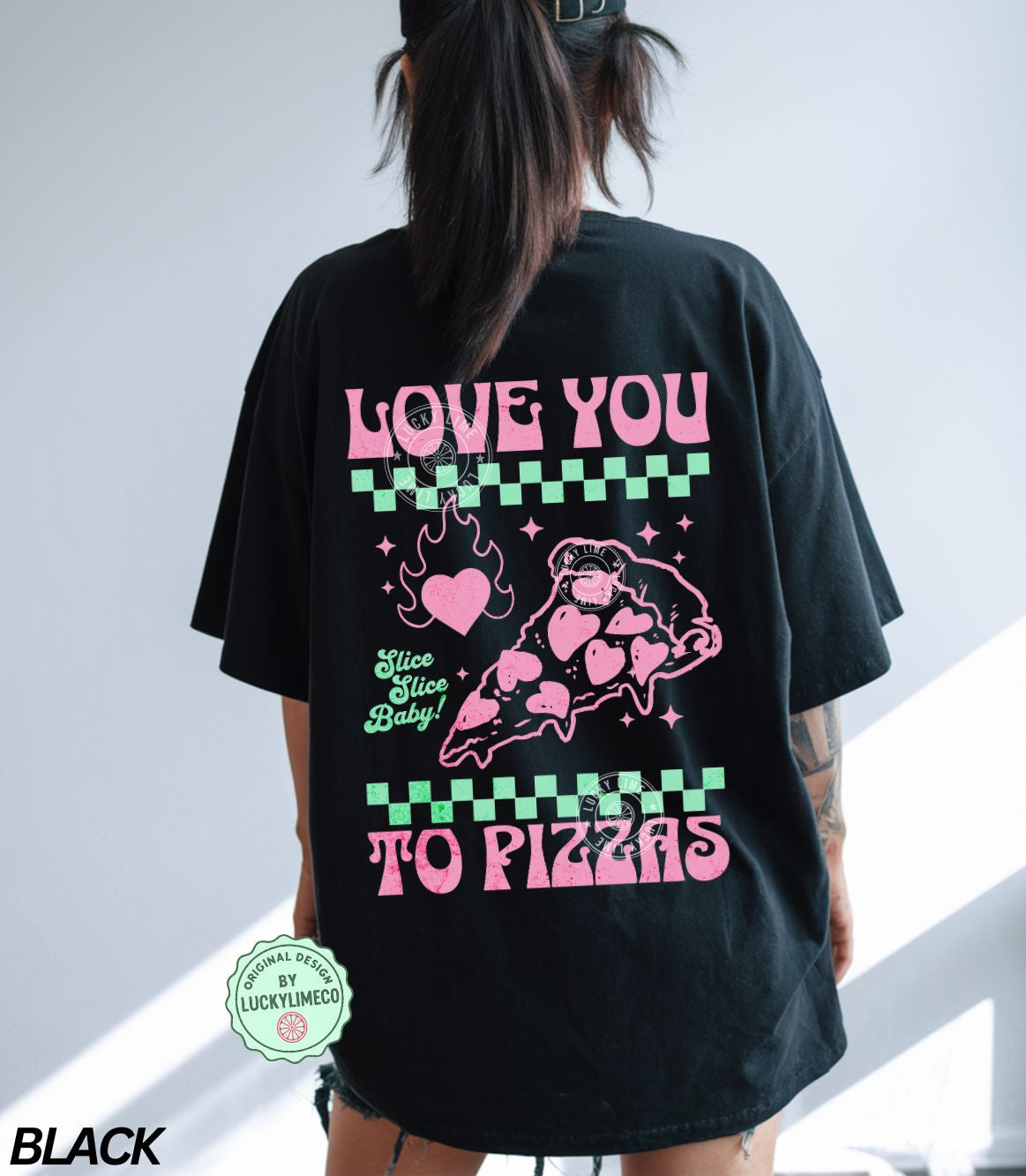 Person wearing a black t-shirt with pink and green graphics and text saying “love you to pizzas”