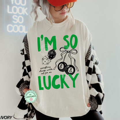 Person wearing an ivory shirt with 'I'm so lucky' text and dice graphics, with a red cap and black and white checkered sleeves.