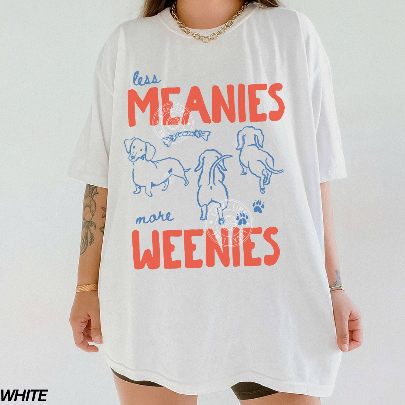 White t-shirt with colorful text and dog illustrations on a plain background