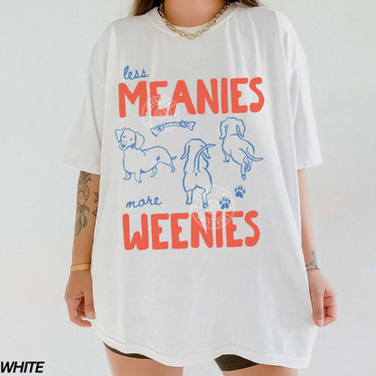 White t-shirt with colorful text and dog illustrations on a plain background