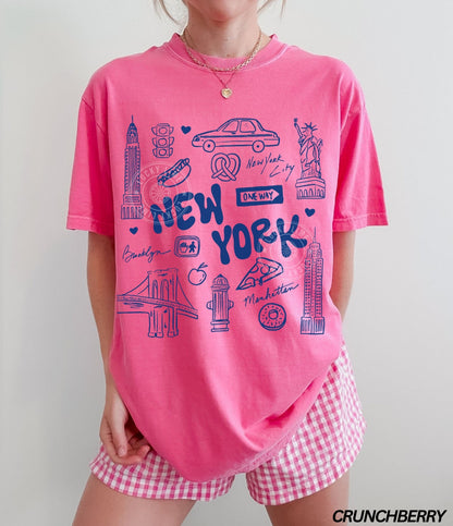 Person wearing a pink 'New York' t-shirt and checkered shorts with.